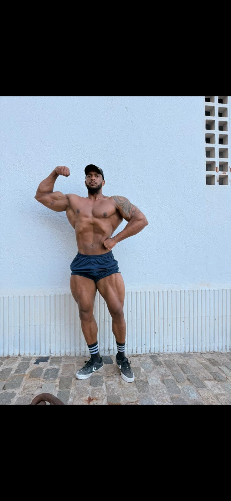 Dairot, professional bodybuilder, posando un doble bíceps frontal